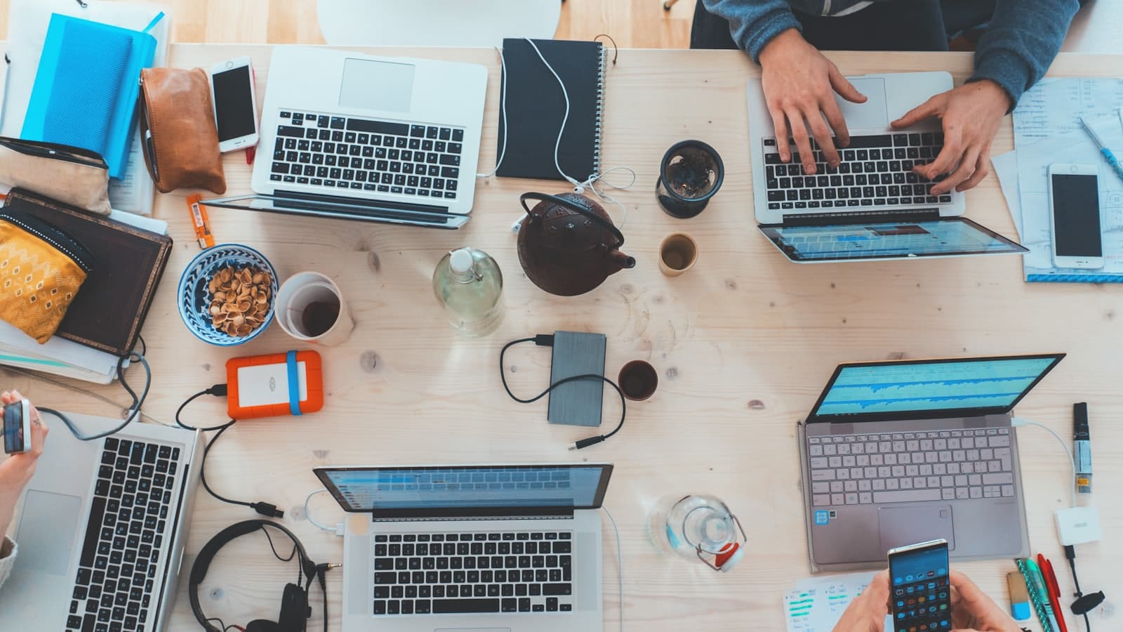 A table of laptops and phones photographed from above