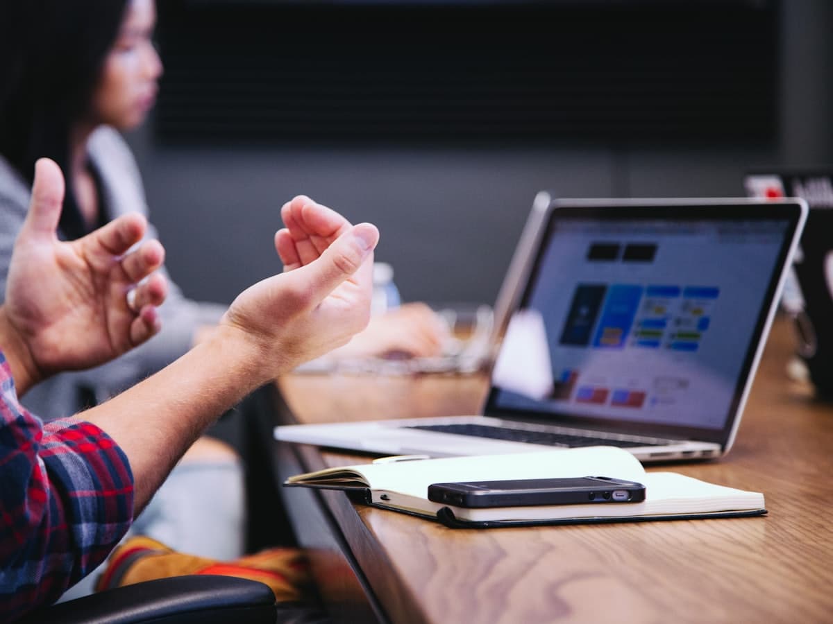 Hands mid-explanation across a table during a review